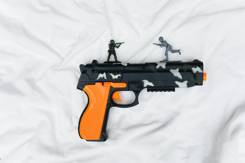 plastic pistol on white sheet